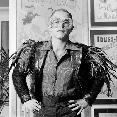 English pop singer Elton John in a flamboyant stage outfit of feather trimmed jacket and rhinestone encrusted glasses, circa 1973.
