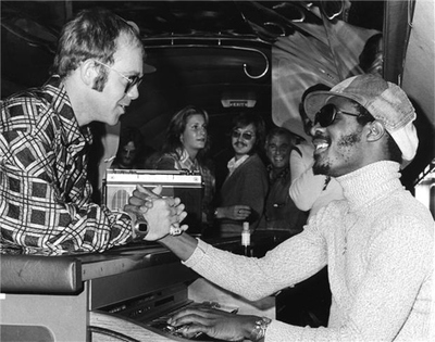 Elton John, Suzee Carnel and Stevie Wonder on Starship 1 airplane in Boston, MA. September 24, 1973.
