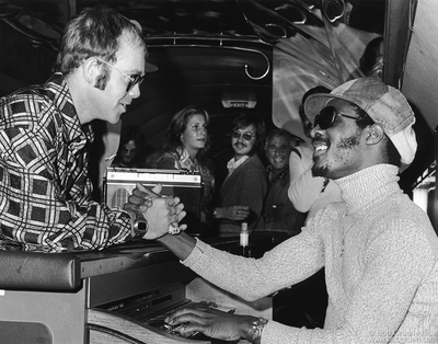 Elton John, Suzee Carnel and Stevie Wonder on Starship 1 airplane in Boston, MA. September 24, 1973.
