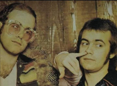 Elton John & Bernie Taupin, Los Angeles - An early portrait of Elton John with his long-time collaborator Bernie Taupin, taken when they made their first visit to Ed Caraeff’s Coldwater Canyon living room/photography studio.
