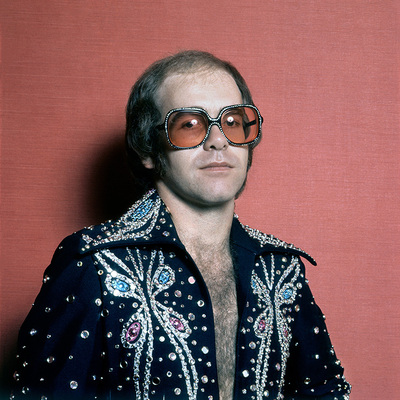 English pop singer Elton John in a rhinestone jacket and matching glasses, circa 1975.
