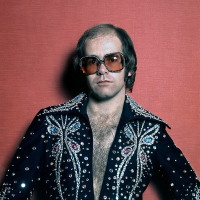 English pop singer Elton John in a rhinestone jacket and matching glasses, circa 1975.
