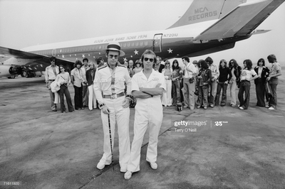 PHOTOGRAPHED BY TERRY O'NEILL
English pop star and pianist Elton John stands with long time collaborator Bernie Taupin in front of his private Boeing jet during his 1974 US tour.
