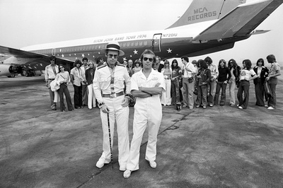 PHOTOGRAPHED BY TERRY O'NEILL
English pop star and pianist Elton John stands with long time collaborator Bernie Taupin in front of his private Boeing jet during his 1974 US tour.
