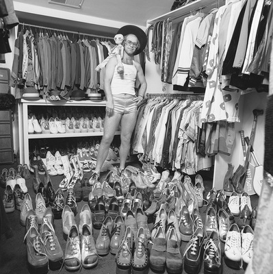 Elton John at home in London, 1975, with part of his wardrobe, notably a large collection of platform shoes.
“That’s a great one. When I was at his home, I suggested we just walk around and I’ll take some photos of him with some of his collections. I was thinking at the time, he’ll show me some sculptures or paintings. Little did I know what I was getting myself into!” – Terry O’Neill
