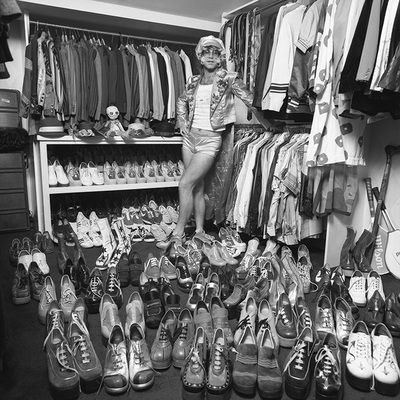 Elton John at home in London, 1975, with part of his wardrobe, notably a large collection of platform shoes.
“That’s a great one. When I was at his home, I suggested we just walk around and I’ll take some photos of him with some of his collections. I was thinking at the time, he’ll show me some sculptures or paintings. Little did I know what I was getting myself into!” – Terry O’Neill
