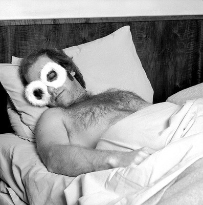 English singer and songwriter Elton John sleeps in the bed of his airplane, 1975.
