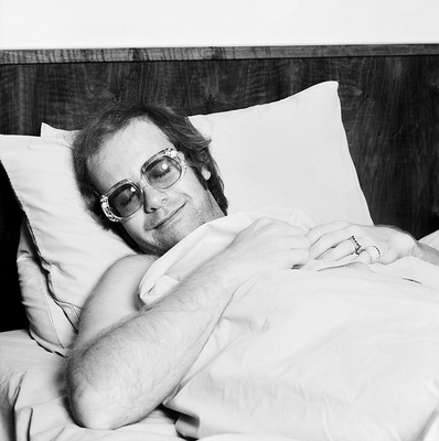 English singer and songwriter Elton John sleeps in the bed of his airplane, 1975.
