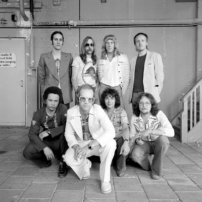 English singer and songwriter Elton John poses with his band for the “Louder than Condord but not quite as Pretty” programme, 1976.
