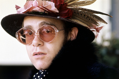 English pop singer Elton John poses for a portrait in a fur coat, hat and glasses, circa 1975.
