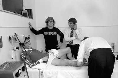 English pop singer and songwriter Elton John meets players from Watford Football Club, circa 1970s.
