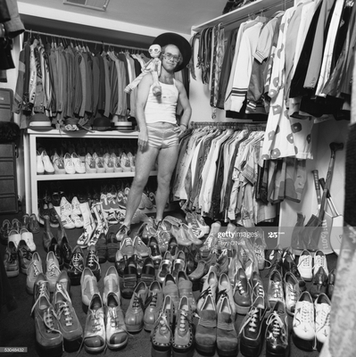 Elton John at home in London, 1975, with part of his wardrobe, notably a large collection of platform shoes.
“That’s a great one. When I was at his home, I suggested we just walk around and I’ll take some photos of him with some of his collections. I was thinking at the time, he’ll show me some sculptures or paintings. Little did I know what I was getting myself into!” – Terry O’Neill
