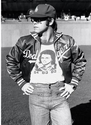 PHOTOGRAPHED BY TERRY O'NEILL
“This was during the sound-check for the Dodger Stadium concert series. Billie Jean King was – and is – a great friend of Elton’s. And I saw he was wearing his “Battle of the Sexes” shirt – that was the famous tennis match between Billie Jean King and Bobby Riggs -where BJK won in three straight sets – you can see the scores on the shirt.” -Terry O’Neill
