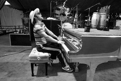 PHOTOGRAPHED BY TERRY O'NEILL
English singer songwriter Elton John rehearses at Dodger Stadium in Los Angeles, 1975.
