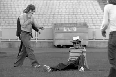 PHOTOGRAPHED BY TERRY O'NEILL
English singer songwriter Elton John playing football before his performance at Dodger Stadium in Los Angeles, 1975.
