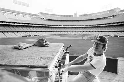 PHOTOGRAPHED BY TERRY O'NEILL
English singer songwriter Elton John rehearses at Dodger Stadium in Los Angeles, 1975.
