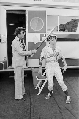 PHOTOGRAPHED BY TERRY O'NEILL
British television presenter Russell Harty and pop singer Elton John backstage at Dodger Stadium, October 1975.
