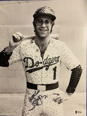 PHOTOGRAPHED BY TERRY O'NEILL
English singer and songwriter Elton John poses in Bob Mackie’s now famous sequined white Dodgers uniform at Dodger Stadium in Los Angeles, October 1975.
