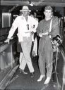 sir-elton-john-singer-and-musician-1978-elton-john-and-rod-stewart-on-a-fashion-parade-at-london-airport-as-they-just-flew-in-from-rio-rod-wears-a-wide-brim-hat-resembling-a-great-white-hunters-topee-elton-looks-as-if-he-has-flwon-in-from-a.jpg