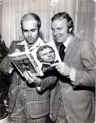 elton-john-without-glasses-with-bobby-moore-at-the-launch-of-bobby-moores-autobiography-written-by-sportsmails-jeff-powell-bobby-was-born-12-april-1941-in-barking-essex-died-24-february-1993-at-home-in-putney-southwest-london-following-a-st.jpg