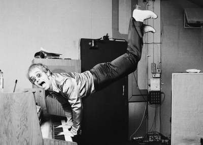 Musician and singer Elton John performing a handstand on his piano, London 1972.
