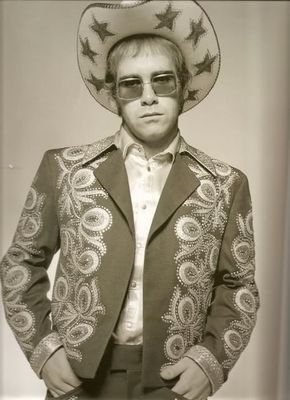 English pop star and pianist Elton John wearing a floral applique suit and sunglasses during a photoshoot in promotion of his album ‘Honkey Chateau’, 1972.
