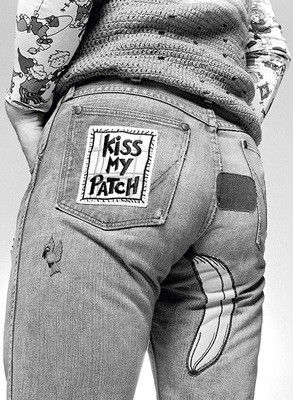 British pop singer, songwriter and musician Elton John shows off the patches on the back of his jeans, circa 1970s.
