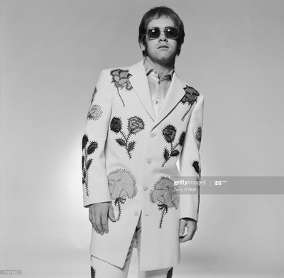 English pop star and pianist Elton John wearing a floral applique suit and sunglasses during a photoshoot in promotion of his album ‘Honkey Chateau’, 1972.
